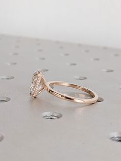 a diamond ring sitting on top of a metal surface with dots around it and the center stone in the middle