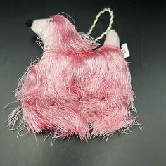 a stuffed animal that looks like a dog with pink fur on it's back