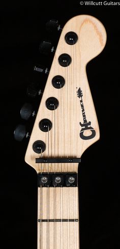 an electric guitar neck with black knobs on the top and bottom, against a black background