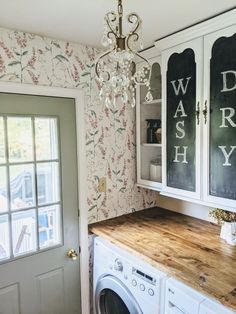 a washer and dryer in a room with floral wallpaper on the walls