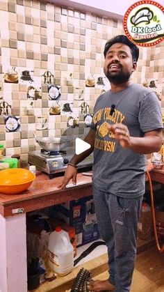 a man standing in front of a counter with food on top of it and a frying pan behind him