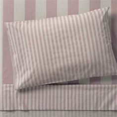 a pink and white striped bed spread with two pillows on top of each pillowcase