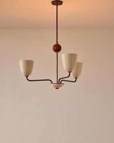 a chandelier hanging from the ceiling in a room with white walls and flooring