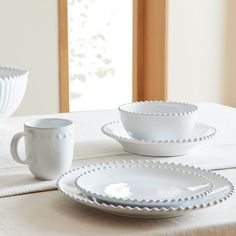 a table with white dishes and cups on it