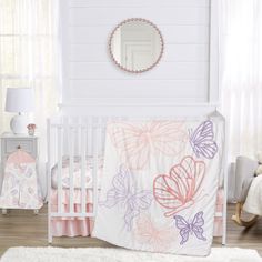 a white crib with pink, purple and orange butterflies on the bed coverlet