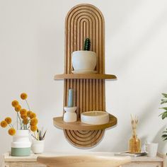 a wooden shelf with some vases and other items on it in a white room