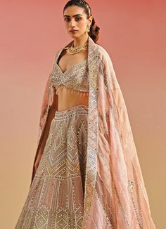 Featuring an enchanting salmon pink organza blouse, adorned with intricate gota patti, mirror work and playful tassels. Elegantly paired with a pink lehenga fully embellished with gota and mirror work and a matching multi shaded ethereal organza dupatta with mirror embellishments. Composition : Organza Care: Dry Clean Only and Vacuum Storage This product can be customized for sleeves, length of blouse and neckline Delivery : 6-8 weeks as the product is hand crafted. Check Size Guide or choose MySize for free customisation (All Sizes above XL can be made at 15% additional cost) For more information and sizes please contact fabiliciousfashion@gmail.com or visit our Copenhagen studio. Studio Iris, Cancan Lehenga, Mirror Work Lehenga, Geometric Mirror, Embroidery Mirror, Organza Embroidery, Organza Lehenga, Mirror Embroidery, Organza Blouse