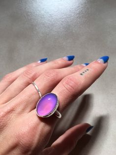 "This ring features a 13x18mm oval Mood stone bezel set in a handmade serrated bezel. The band is a thick half-round. The mood stone changes colors varying from yellow, green, blue, and purple! A small heart is stamped into the back of the ring :) I can also add an arrow or letter/number(s) or your choice if you prefer, just let me know in the note to seller section! You can choose from sterling silver, 14k yellow gold-fill, or 14k rose gold-fill. If you would prefer a different karat or type of Oval Cabochon Jewelry With Smooth Bezel For Gift, Unique Oval Moonstone Ring With Bezel Setting, Oval Sterling Silver Ring With Smooth Bezel, Large Oval Moonstone Ring, Adjustable Oval Moonstone Ring With Bezel Setting, Silver Oval Ring With Smooth Bezel, Oval Purple Ring With Bezel Setting, Adjustable Oval Opal Ring With Large Stone, Adjustable Oval Cabochon Ring With Large Stone