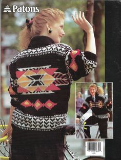 a woman in a black sweater is waving to someone on the street with her bike