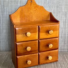 a wooden dresser with four drawers and knobs