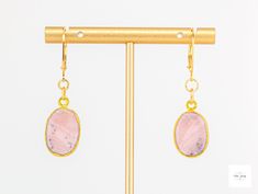 Behold these lovely gold-leafed pink Peruvian opal drop earrings! They exude understated elegance and add a modern feminine touch to your look. They are easily dressed up or down, and are perfect for any occasion. Beautiful, smooth, gold-leafed pink Peruvian opal bezels. These beautiful stones have natural patterns in shades for pink, grey, white, dusty rose pink coral pink, black and white. Gold-plated lever backs for a secure and comfortable fit. 1.75 inches longThese unique and beautiful earrings are perfect for a special gift or addition to your own collection! Due to natural variations in the gemstones your purchased item may not be identical to the one pictured. There may be natural but slight asymmetries (small differences) and imperfections in the size, shapes, colors, and patterns Elegant Pink Opal Jewelry Gift, Elegant Pink Opal Jewelry For Gift, Elegant Pink Opal Oval Jewelry, Elegant Gold Jewelry With Pink Opal, Elegant Pink Opal Jewelry For Formal Occasions, Elegant Formal Pink Opal Jewelry, Elegant Pink Opal Jewelry With Natural Stones, Handmade Elegant Pink Opal Jewelry, Single Opal Earring As A Gift