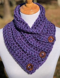 a purple cowl with buttons is on a mannequin