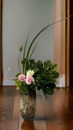 a vase filled with flowers on top of a wooden floor