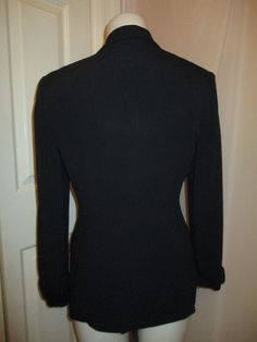 "From around the 1990's. Nicely fitted double breasted. 75% acetate, 25% rayon. Dry clean. Single button closure with interior button. Front button flap pockets. Shiny satin fabric on collar, cuffs, pocket flaps and covered buttons. It has med/large shoulder pads. Marked size 4. Runs true to size. It fits me and I wear a 4. It measures 26\" long. 23\" sleeves. 16\" across the back of the shoulders. Laying flat seam to seam it's 18\" across under the arms, 15 1/2\" at the waist. Overall very good Classic Single Breasted V-neck Outerwear, Winter V-neck Blazer With Buttons, Fitted V-neck Outerwear For Work, Fitted V-neck Outerwear With Double Button Closure, Fitted Button-up Blazer With Double Button Closure, Solid Long Sleeve Career Blazer, Career Long Sleeve Solid Blazer, Career Blazer With Long Sleeves, Tailored Long Sleeve Blazer With Buttons