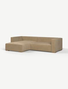 a beige sectional couch sitting on top of a white floor