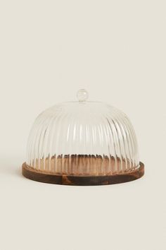 a clear glass dome with wooden base