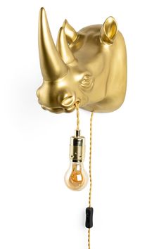 a gold rhino head with a light bulb attached to it