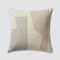 a beige and grey pillow with an abstract design on the front, sitting on a gray background