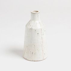 a white vase sitting on top of a table