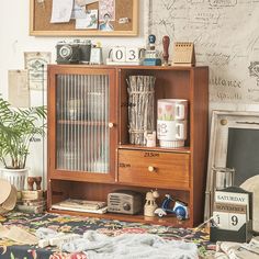 a wooden cabinet with drawers and pictures on the wall next to other items in a room