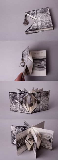 an origami book opened to show the pages folded in two different directions and being held by a metal hook