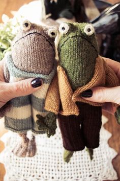 two knitted frog dolls sitting next to each other