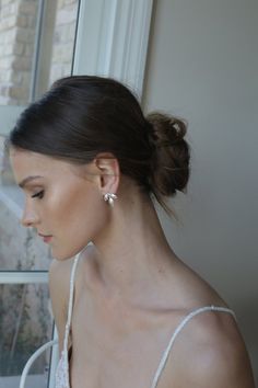 a woman in a white dress looking out the window