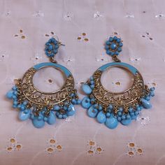 These beautiful pieces are Long Circular Goldtone Filigree Pierced Earrings Enhanced with Blue Enamel and Blue Stone Drops. The Stud is a Goldtone Circle Enhanced with Blue Stones with the longer Filigree section below. No maker's mark found. Used but in excellent condition. Dimensions are 3 inches by 2 inches. Traditional Blue Danglers For Pierced Ears, Blue Metal Beaded Earrings For Pierced Ears, Traditional Blue Danglers, Blue Bohemian Metal Hoop Earrings, Blue Bohemian Hoop Earrings For Pierced Ears, Handmade Blue Bohemian Clip-on Earrings, Blue Bohemian Hoop Earrings, Blue Metal Earrings With Dangling Beads, Blue Round Beaded Metal Earrings