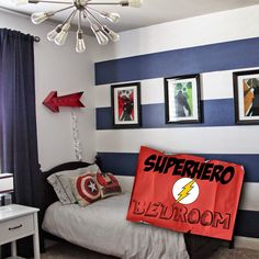 a bedroom decorated in blue, white and red with pictures on the wall above the bed