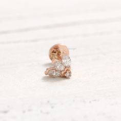 a pair of diamond earrings sitting on top of a white surface