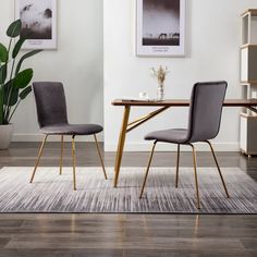 a dining room table with two chairs and a rug on the floor in front of it