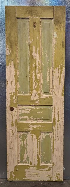 an old wooden door with peeling paint on the front and side doors, painted green