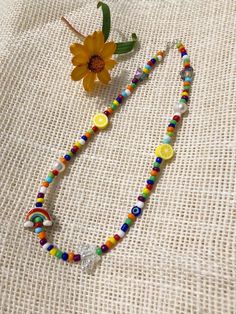 "This super cute and trendy beaded 15\" choker is the perfect summer statement piece! It's finished with a sterling silver clasp, and it features rainbow beads, as well as an assortment of eclectic shaped beads, like butterflies, rainbows, lemons, evil eyes, and freshwater pearls.  What's not to love??  Pearls represent purity, generosity, spirituality, femininity, and beauty. The evil eye represents protection from negative energy that can cause bad luck or loss.  It's important to wear an evil eye to ward off this bad energy. The butterfly is a symbol of a powerful transformation.  It represents creativity, endless potential, vibrant joy, gracefulness, romance, and renewal. Handle your jewelry with care! Keep it safe and shiny for as long as possible by storing in a dry place and avoidin Trendy Rainbow Beaded Necklaces With Round Beads, Trendy Rainbow Beaded Necklace With Round Beads, Adjustable Rainbow Necklace For Summer, Summer Adjustable Rainbow Necklace, Whimsical Multicolor Summer Necklace, Rainbow Tiny Beads Necklace For Summer, Summer Rainbow Beaded Necklaces With Tiny Beads, Rainbow Beaded Necklaces For Summer, Rainbow Round Beads Necklace For Summer