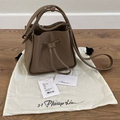 3.1 Phillip Lim Soleil Mini Bucket Drawstring Bag Color: Coffee (Light Brown/Taupe) Silver Hardware Style: As22-0132nbl Open Top With Drawstring Closure Approximately 7'h X 8'w X 4.25'd Approximately 18-21.5' Shoulder Strap Drop Leather Very Good Pre-Owned Condition (See Last Pic For A Slight Scuff) Comes With Dust Bag And Care Card Drawstring Purse, Mini Bucket, Color Coffee, Care Card, 3.1 Phillip Lim, Open Top, Phillip Lim, Silver Hardware, Drawstring Bag