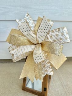 a gold and white bow on top of a wooden stand