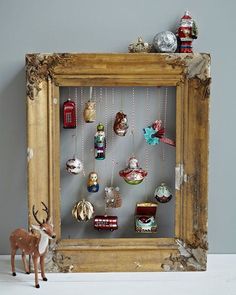 an old frame with ornaments hanging from it's sides and a deer figurine in the middle