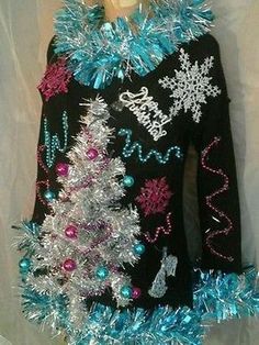 a black sweater with blue and silver tinsel on the bottom has snowflakes around it