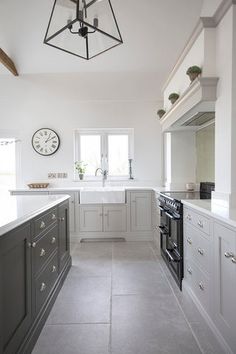 a kitchen with an oven, counter tops and cabinets in white and grey colors is shown