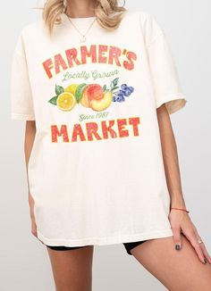 This Farmer's Market T-Shirt offers a relaxed adult fit and is made with heavyweight Comfort Colors for ultimate comfort. The trendy vintage retro design features a typography of "Farmer's Market - Locally Grown" with a colorful illustration of peach, lemon, and berry. Show your support for local produce while looking stylish and feeling comfortable. S:M:L:XL *Size Chart Available Garment Dyed Cotton 100% Machine Wash Delicate cycle with like colors Retro Faded T-shirt With Letter Print, Vintage Text Print T-shirt For Spring, Oversized Acid Wash Vintage T-shirt, Oversized Retro T-shirt With Text Print, Vintage Oversized Soft-washed T-shirt, Oversized Soft-washed Vintage T-shirt, Oversized Vintage Soft-washed T-shirt, Vintage Oversized Tops With Lettering, Vintage Oversized Top With Lettering