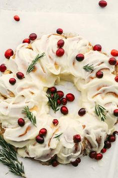 a white plate topped with a cake covered in icing and cranberries