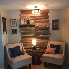 two chairs sitting next to each other in front of a wall with wood planks