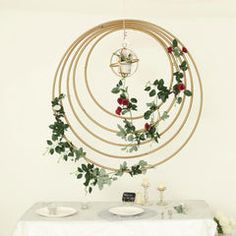 a table topped with a white table cloth covered table and a gold circular decoration hanging from the ceiling