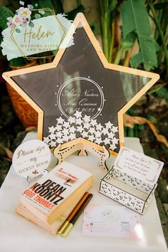 a star shaped sign sitting on top of a table next to some books and other items