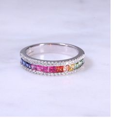 a rainbow colored diamond ring on a white background