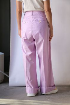 Sale items are final sale. No returns or exchanges. Expertly crafted from soft cotton, these pleated lilac pants feature a high rise and double pleats, providing both comfort and style. The white button fastening closure and belt loops add functional details, while the side slip pockets and back buttoned pockets add a touch of practicality. Perfect for any occasion. Need further assistance? Text our stylists for more details about fit, fabrication, photos etc! Relaxed fit, we suggest ordering a Purple Cotton Wide Leg Pants For Spring, High-waist Lavender Pants For Spring, Purple Cotton Bottoms For Daywear, Purple Cotton Bottoms With Belt Loops, Lavender Wide Leg Cotton Bottoms, Spring Lavender Relaxed Fit Bottoms, Summer Lavender Cotton Pants, Lavender Cotton Bottoms Relaxed Fit, Lavender Cotton Bottoms With Relaxed Fit