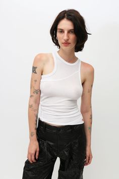 Crafted from an open gauge, semi-sheer rib fabric, this high-neck tank features a unique bias cut designed to twist when worn. Showcasing an asymmetrical hem and is finished with a red-stitched EL logo on the lower left front. Asymmetrical Fitted Tank Top For Layering, Fitted Asymmetrical Tank Top For Layering, Casual White Asymmetrical Tank Top, Fitted Casual Tank Top With Asymmetrical Hem, Eckhaus Latta, Rib Fabric, Ny Fashion, High Neck Tank, Asymmetrical Hem