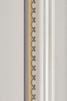 a close up of a white door with a yellow strip on the side and grey trim around it