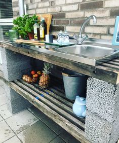 a kitchen sink sitting on top of a wooden counter next to a metal faucet