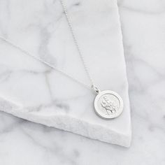 LILY & ROO's beautiful small sterling silver round St Christopher necklace. This beautiful circular pendant is suitable for everyday wear and perfect for layering. The small round St Christopher features the patron saint of travellers. The perfect jewellery gift for her. All silver St Christophers come in a luxury LILY & ROO gift box. Give your jewellery a little TLC to keep your jewellery shining bright. Your stunning St Christopher necklace will be sent to you in a complimentary Lily & Roo gif Sterling Silver Tarnish Resistant Medallion Necklace, Tarnish Resistant Sterling Silver Medallion Necklace, Silver Polished Medallion Necklace, Nickel-free Sterling Silver Medallion Necklace, Silver Spiritual Medallion Necklace, Spiritual Silver Medallion Necklace Tarnish Resistant, Silver Spiritual Medallion Necklace Tarnish Resistant, Spiritual Silver Medallion Necklace, Sterling Silver Coin Pendant Charm Necklaces