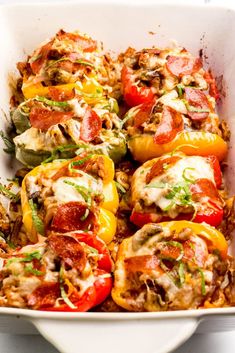 a white casserole dish filled with stuffed bell peppers and other toppings, ready to be eaten